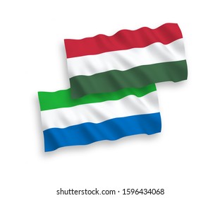 National vector fabric wave flags of Sierra Leone and Hungary isolated on white background. 1 to 2 proportion.