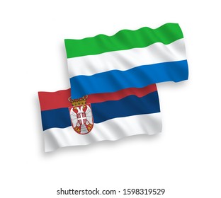 National vector fabric wave flags of Sierra Leone and Serbia isolated on white background. 1 to 2 proportion.
