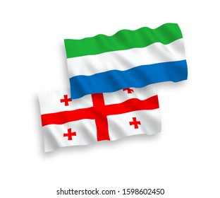 National vector fabric wave flags of Sierra Leone and Georgia isolated on white background. 1 to 2 proportion.