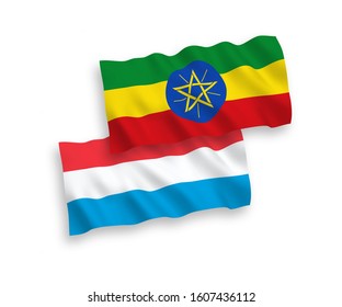 National vector fabric wave flags of Ethiopia and Luxembourg isolated on white background. 1 to 2 proportion.