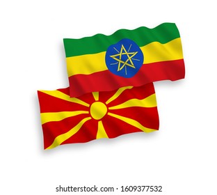 National vector fabric wave flags of Ethiopia and North Macedonia isolated on white background. 1 to 2 proportion.