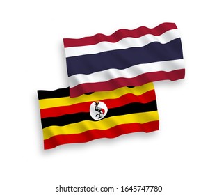 National vector fabric wave flags of Uganda and Thailand isolated on white background. 1 to 2 proportion.