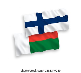 National vector fabric wave flags of Finland and Madagascar isolated on white background. 1 to 2 proportion.