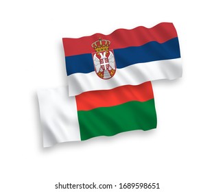 Banderas de olas de tela vectorial nacional de Madagascar y Serbia aisladas en fondo blanco. 1 a 2 proporciones.