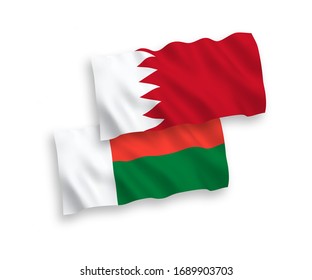 National vector fabric wave flags of Madagascar and Bahrain isolated on white background. 1 to 2 proportion.