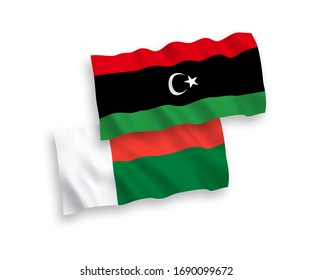 National vector fabric wave flags of Madagascar and Libya isolated on white background. 1 to 2 proportion.