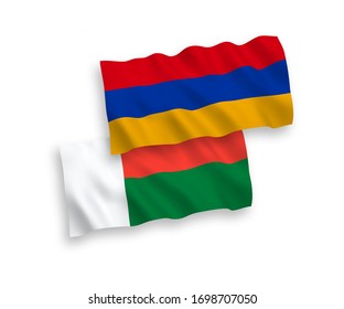 National vector fabric wave flags of Armenia and Madagascar isolated on white background. 1 to 2 proportion.