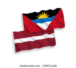 National vector fabric wave flags of Latvia and Antigua and Barbuda isolated on white background. 1 to 2 proportion.