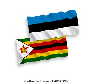 National vector fabric wave flags of Estonia and Zimbabwe isolated on white background. 1 to 2 proportion.