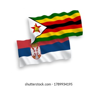 National vector fabric wave flags of Zimbabwe and Serbia isolated on white background. 1 to 2 proportion.