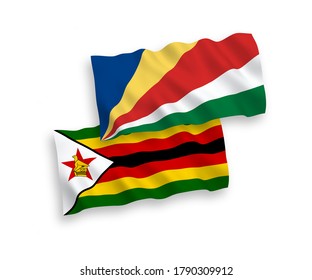 National vector fabric wave flags of Zimbabwe and Seychelles isolated on white background. 1 to 2 proportion.