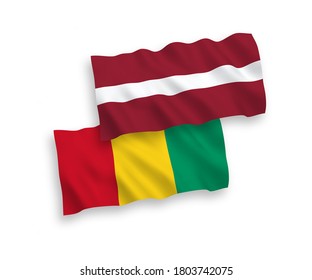 National vector fabric wave flags of Latvia and Guinea isolated on white background. 1 to 2 proportion.