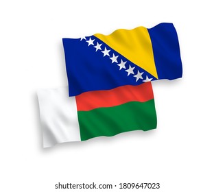 National vector fabric wave flags of Bosnia and Herzegovina and Madagascar isolated on white background. 1 to 2 proportion.