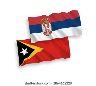 National vector fabric wave flags of East Timor and Serbia isolated on white background. 1 to 2 proportion.