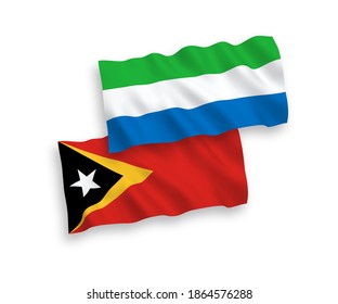 National vector fabric wave flags of East Timor and Sierra Leone isolated on white background. 1 to 2 proportion.