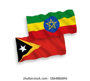 National vector fabric wave flags of East Timor and Ethiopia isolated on white background. 1 to 2 proportion.