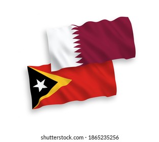 National vector fabric wave flags of East Timor and Qatar isolated on white background. 1 to 2 proportion.