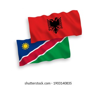 National vector fabric wave flags of Republic of Namibia and Albania isolated on white background. 1 to 2 proportion.