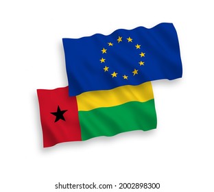 National vector fabric wave flags of European Union and Republic of Guinea Bissau isolated on white background. 1 to 2 proportion.