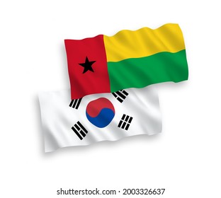 National vector fabric wave flags of South Korea and Republic of Guinea Bissau isolated on white background. 1 to 2 proportion.