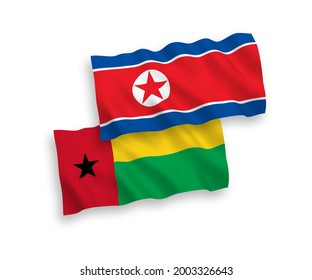 National vector fabric wave flags of North Korea and Republic of Guinea Bissau isolated on white background. 1 to 2 proportion.