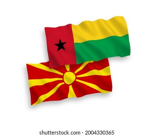 National vector fabric wave flags of Republic of Guinea Bissau and North Macedonia isolated on white background. 1 to 2 proportion.