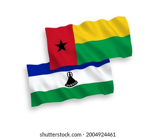 National vector fabric wave flags of Republic of Guinea Bissau and Lesotho isolated on white background. 1 to 2 proportion.
