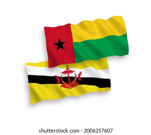National vector fabric wave flags of Republic of Guinea Bissau and Brunei isolated on white background. 1 to 2 proportion.