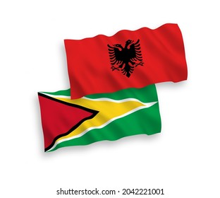 Banderas de ondulación de tela vectorial nacional de la República Cooperativa de Guyana y Albania aisladas de fondo blanco. de 1 a 2.
