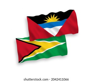 National vector fabric wave flags of Co-operative Republic of Guyana and Antigua and Barbuda isolated on white background. 1 to 2 proportion.