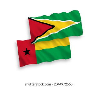 National vector fabric wave flags of Co-operative Republic of Guyana and Republic of Guinea Bissau isolated on white background. 1 to 2 proportion.