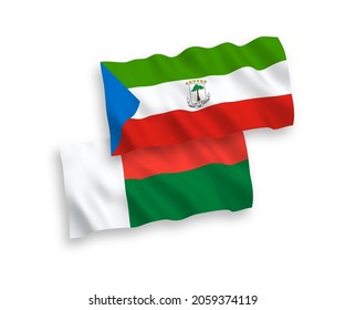 National vector fabric wave flags of Republic of Equatorial Guinea and Madagascar isolated on white background. 1 to 2 proportion.