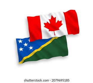 National vector fabric wave flags of Canada and Solomon Islands isolated on white background. 1 to 2 proportion.