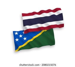 National vector fabric wave flags of Solomon Islands and Thailand isolated on white background. 1 to 2 proportion.