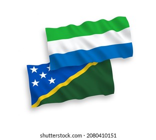 National vector fabric wave flags of Solomon Islands and Sierra Leone isolated on white background. 1 to 2 proportion.