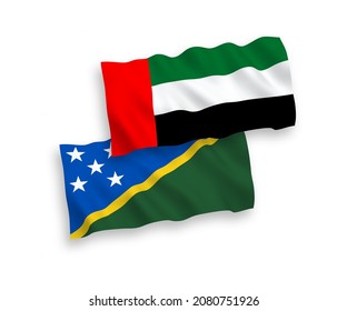 National vector fabric wave flags of Solomon Islands and United Arab Emirates isolated on white background. 1 to 2 proportion.