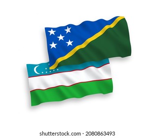 National vector fabric wave flags of Solomon Islands and Uzbekistan isolated on white background. 1 to 2 proportion.