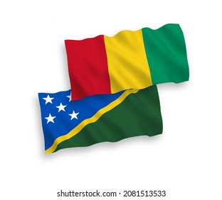 National vector fabric wave flags of Solomon Islands and Guinea isolated on white background. 1 to 2 proportion.
