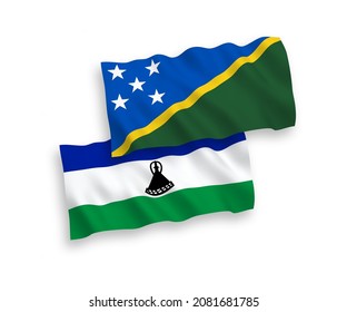 National vector fabric wave flags of Solomon Islands and Lesotho isolated on white background. 1 to 2 proportion.