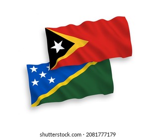 Banderas de olas de tela vectorial nacional de las Islas Salomón y Timor Oriental aisladas en fondo blanco. de 1 a 2.