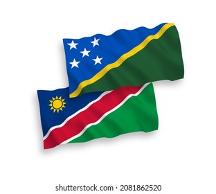 National vector fabric wave flags of Solomon Islands and Republic of Namibia isolated on white background. 1 to 2 proportion.