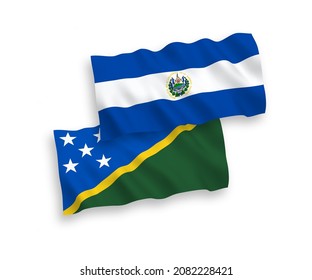 National vector fabric wave flags of Solomon Islands and Republic of El Salvador isolated on white background. 1 to 2 proportion.