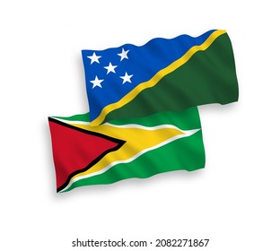 National vector fabric wave flags of Solomon Islands and Co-operative Republic of Guyana isolated on white background. 1 to 2 proportion.
