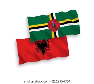 National vector fabric wave flags of Dominica and Albania isolated on white background. 1 to 2 proportion.