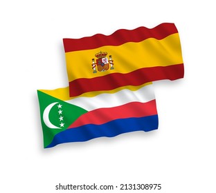 National vector fabric wave flags of Union of the Comoros and Spain isolated on white background. 1 to 2 proportion.