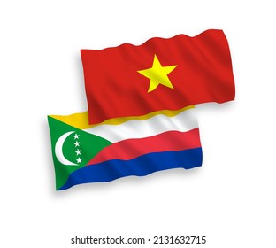 National vector fabric wave flags of Union of the Comoros and Vietnam isolated on white background. 1 to 2 proportion.