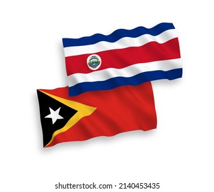 National vector fabric wave flags of Republic of Costa Rica and East Timor isolated on white background. 1 to 2 proportion.