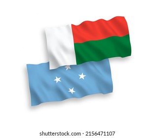 National vector fabric wave flags of Federated States of Micronesia and Madagascar isolated on white background. 1 to 2 proportion.