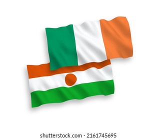 National vector fabric wave flags of Ireland and Republic of the Niger isolated on white background. 1 to 2 proportion.