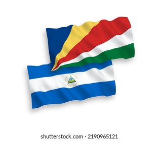National vector fabric wave flags of Nicaragua and Seychelles isolated on white background. 1 to 2 proportion.